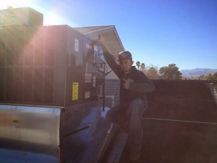 HVAC technician performing HVAC Inspection on a rooftop unit in Hempstead